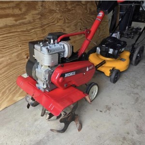 red tiller and yellow push lawnmower